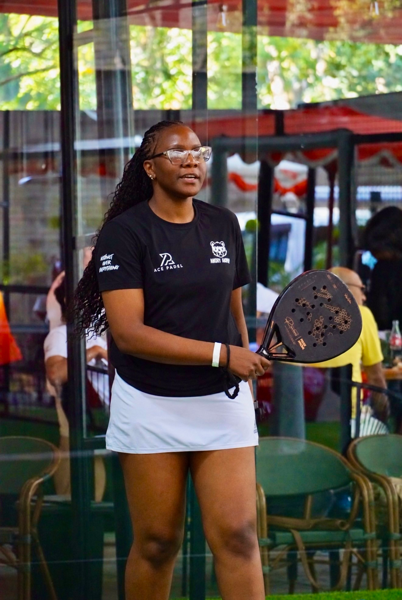 Tonia standing on a padel court with her racket.