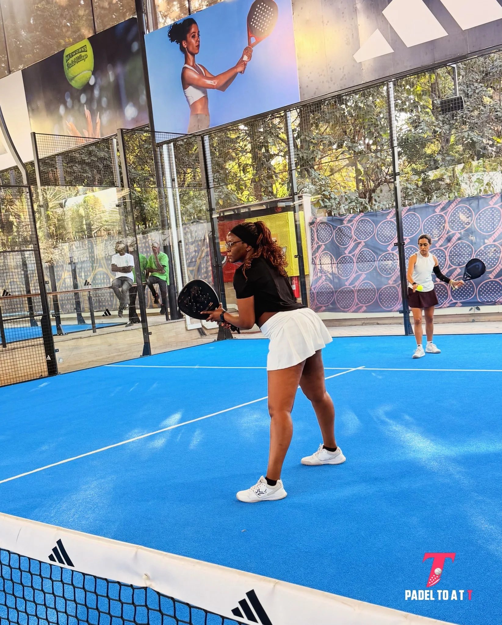 Tonia playing padel on a blue court.